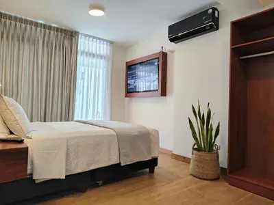 a bedroom with a bed and a tv on the wall at Casa Pucllana Miraflores - Hotel Boutique in Lima