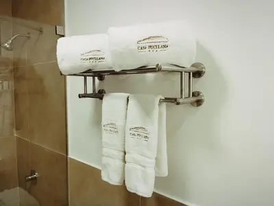 a group of towels hanging on a towel rack in a bathroom at Casa Pucllana Miraflores - Hotel Boutique in Lima