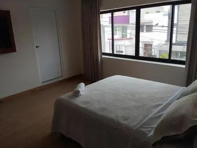 a bedroom with a bed and a large window at Casa Pucllana Miraflores - Hotel Boutique in Lima