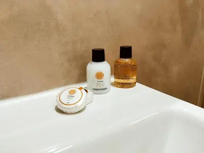 two bottles ofodorizers sitting on top of a white sink at Casa Pucllana Miraflores - Hotel Boutique in Lima