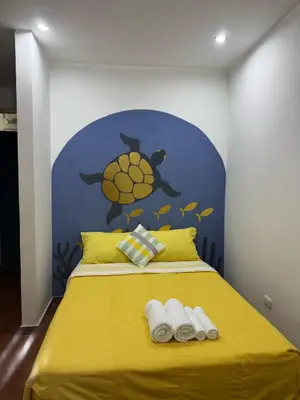 a yellow bed with two towels on top of it at Puerta Azul Hospedaje in Lima