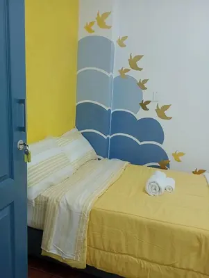 a bedroom with a bed with a blue and yellow wall at Puerta Azul Hospedaje in Lima