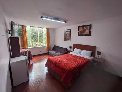 a bedroom with a bed and a couch in it at Sumaq Wasi Caminos Del Inca in Lima
