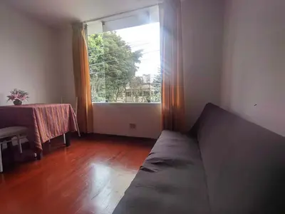 a living room with a couch and a table and a window at Sumaq Wasi Caminos Del Inca in Lima