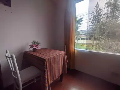 a table and chair in a room with a window at Sumaq Wasi Caminos Del Inca in Lima