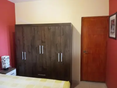 a bedroom with a wooden cabinet and a bed at Casita de Playa in Barranca
