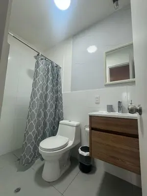 a bathroom with a toilet and a shower curtain at Departamento en el edificio más alto del Perú, a 10 min de Plaza de Armas in Lima