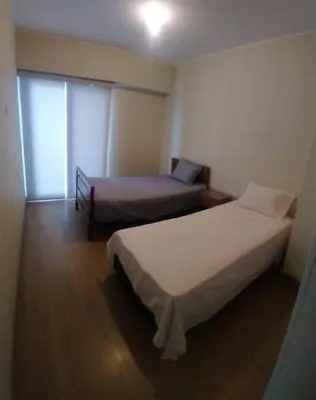 a bedroom with two beds and a window at Departamento en el edificio más alto del Perú, a 10 min de Plaza de Armas in Lima