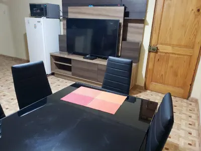 a dining room table with chairs and a television at Carosvi Home in Lima
