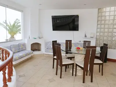 a living room with a table and chairs and a couch at Casa entera con piscina y salida a la playa in Salinas