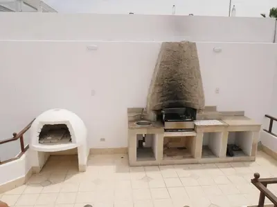a kitchen with a pizza oven in a room at Casa entera con piscina y salida a la playa in Salinas