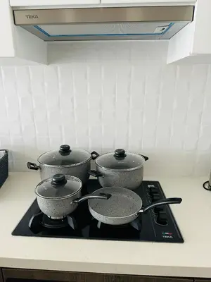 three pots on a stove top in a kitchen at 1Br AC San Isidro Apartment in Lima