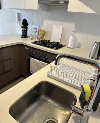 a kitchen sink with a dish drying rack next to it at 1Br AC San Isidro Apartment in Lima