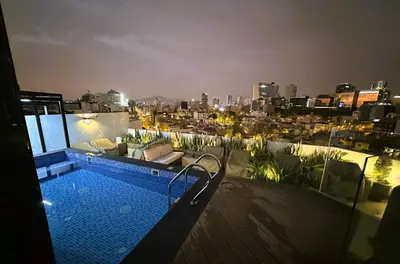 a swimming pool on top of a building with a city skyline at 1Br AC San Isidro Apartment in Lima