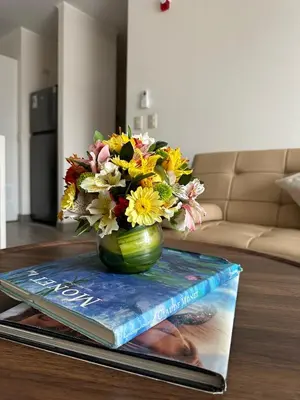 a vase of flowers sitting on top of a book at 1Br AC San Isidro Apartment in Lima