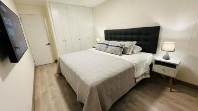 a bedroom with a large bed with a black headboard at 1Br AC San Isidro Apartment in Lima