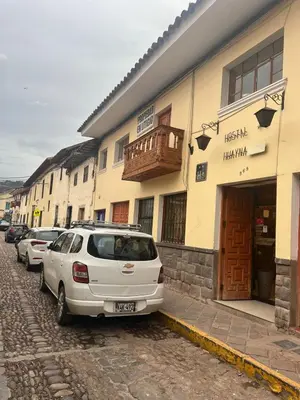 a white car parked in front of a building at HOSTAL HUAYNA HOUSE GO in Cusco
