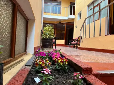 a flower bed on the side of a building with flowers at HOSTAL HUAYNA HOUSE GO in Cusco