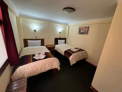 a hotel room with two beds with bows on them at HOSTAL HUAYNA HOUSE GO in Cusco
