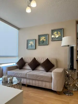 a living room with a couch and a table at dos apartamentos cerca de la laguna de Huacachina in Ica