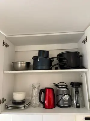 a shelf with pots and pans and other kitchen items at dos apartamentos cerca de la laguna de Huacachina in Ica