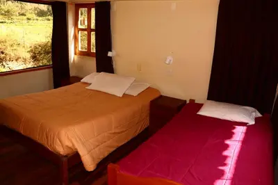 a bedroom with two beds and a window at Full Moon Eco Lodge in Ollantaytambo