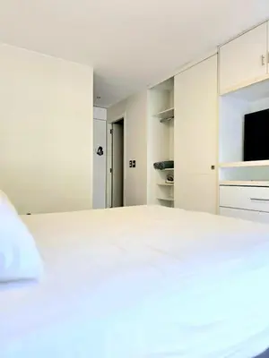 a white bedroom with a bed and a tv at DuplexTOP Miraflores Queen SmartTV Lima 1B 101 in Lima