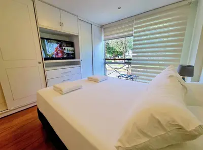 a white bedroom with a large white bed and a window at DuplexTOP Miraflores Queen SmartTV Lima 1B 101 in Lima