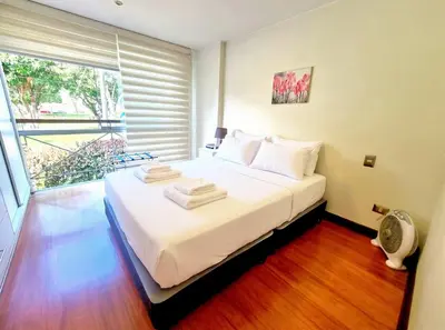 a bedroom with a bed with white sheets and a window at DuplexTOP Miraflores Queen SmartTV Lima 1B 101 in Lima