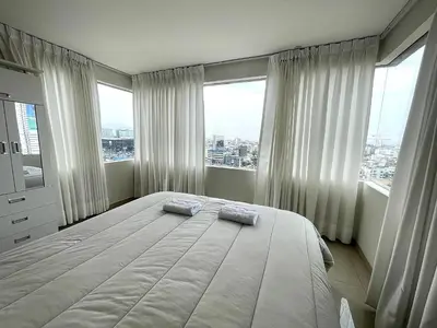 a bedroom with a large bed with two pillows on it at Departamento con vista de Lima in Lima