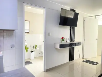 a white bathroom with a sink and a mirror at Departamento con vista de Lima in Lima