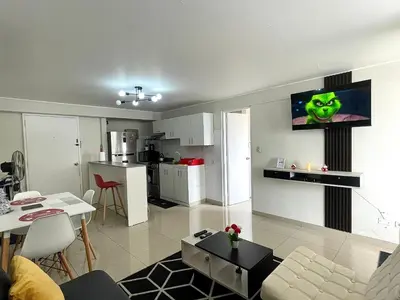 a living room and kitchen with a television on the wall at Departamento con vista de Lima in Lima