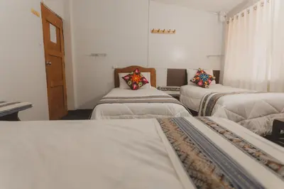 a room with three beds with pillows on them at Lucios Cusco in Cusco