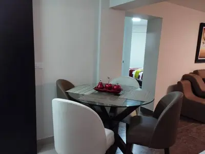 a dining room with a table and white chairs at Mini Apartamento, cerca al Malecón de Chorrillos in Lima