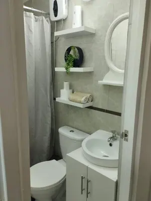 a bathroom with a toilet and a sink and a mirror at Mini Apartamento, cerca al Malecón de Chorrillos in Lima