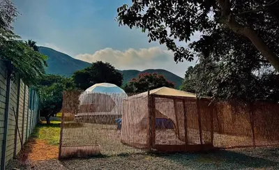 a fence in front of a field with mountains in the background at Amaya Experience in Miraflores