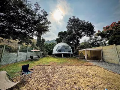 a tent in a field with a chair in a yard at Amaya Experience in Miraflores