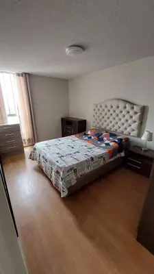 a bedroom with a bed with a quilt on it at Apartamento Varela 3 dormitorios in Lima
