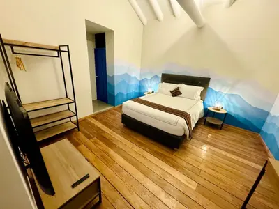 a bedroom with a bed and a mirror in it at Way Kap Hostel Cusco in Cusco
