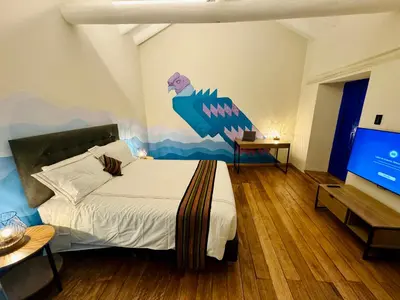 a bedroom with a bed with a fish on the wall at Way Kap Hostel Cusco in Cusco