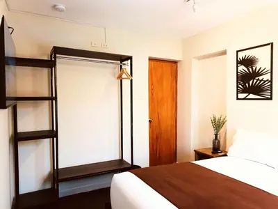 a bedroom with a bed and a wooden door at Casa Pardo in Cusco