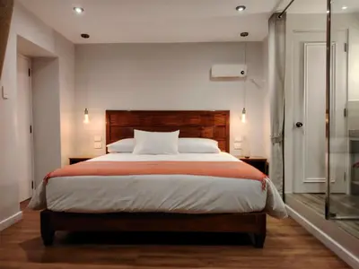 a bedroom with a large bed and a glass door at Casa Cruz Verde by Peru Garden Hotels in Cusco