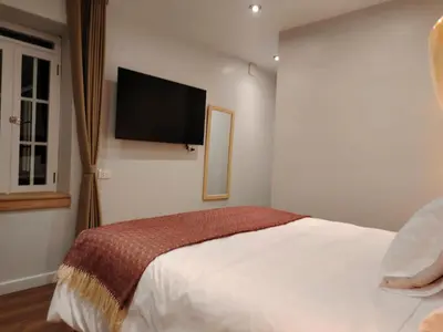a bedroom with a bed with a flat screen tv on the wall at Casa Cruz Verde by Peru Garden Hotels in Cusco