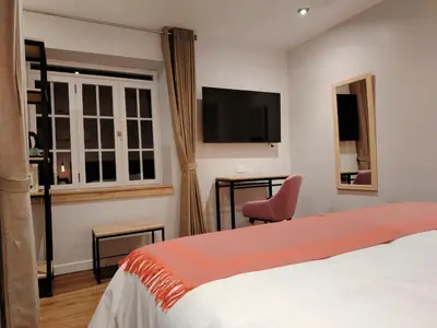 a bedroom with a bed and a chair and a tv at Casa Cruz Verde by Peru Garden Hotels in Cusco