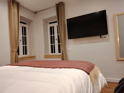 a bedroom with a bed with a flat screen tv on the wall at Casa Cruz Verde by Peru Garden Hotels in Cusco
