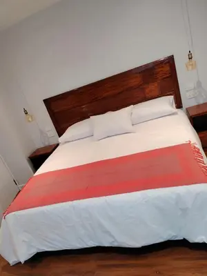 a bedroom with a large bed with a wooden headboard at Casa Cruz Verde by Peru Garden Hotels in Cusco