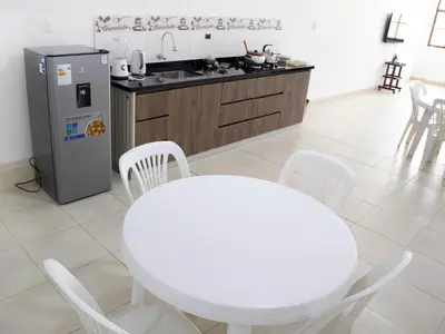 a kitchen with a white table and a refrigerator at Resort Maldo in Ayacucho