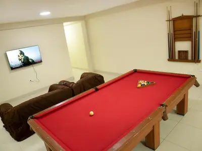 a red pool table in a room with a couch at Resort Maldo in Ayacucho