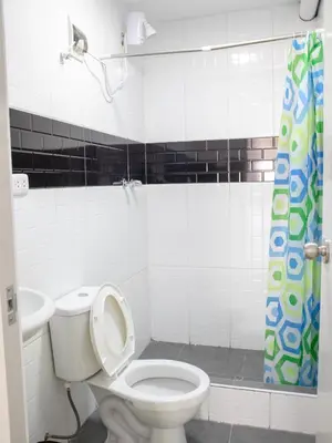a bathroom with a toilet and a shower curtain at Resort Maldo in Ayacucho