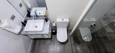 a white bathroom with a sink and a toilet at Departamento de Estreno en Miraflores in Lima